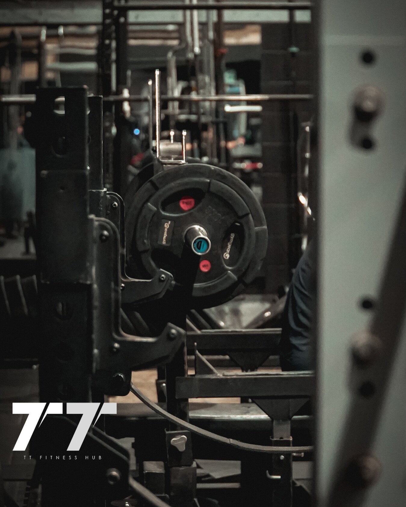 Power racks and loaded plates on the TT Fitness Hub floor