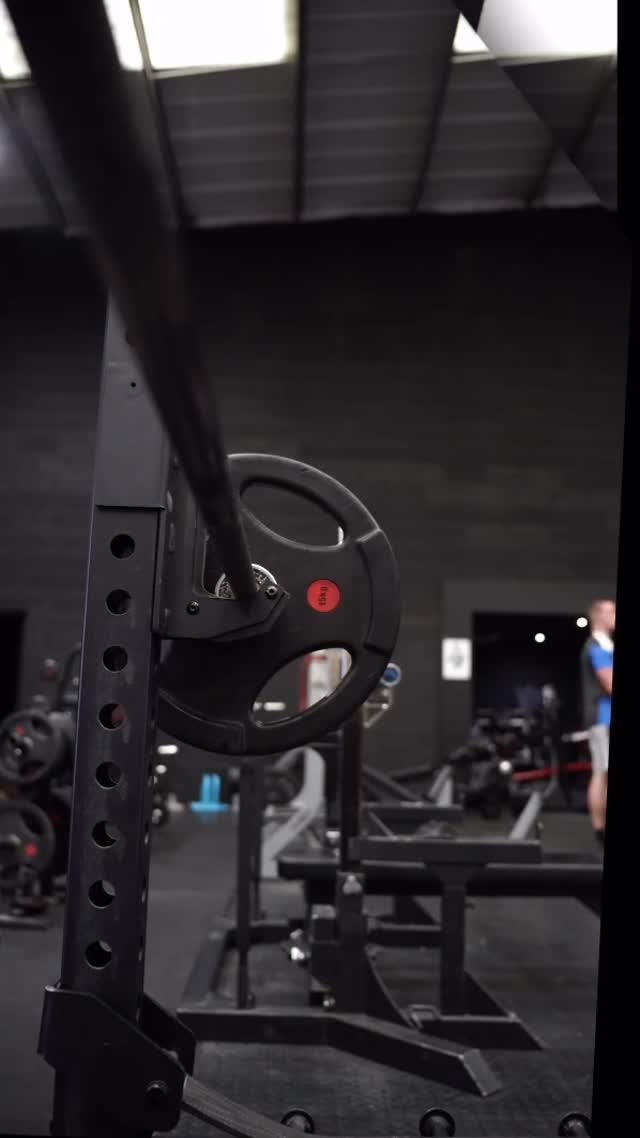 Loaded barbell in a rack on the gym floor